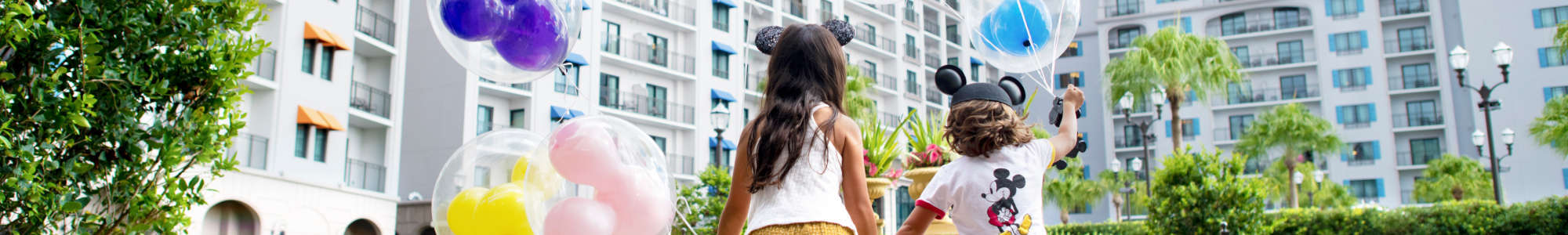 Two young guests with Mickey balloons.
